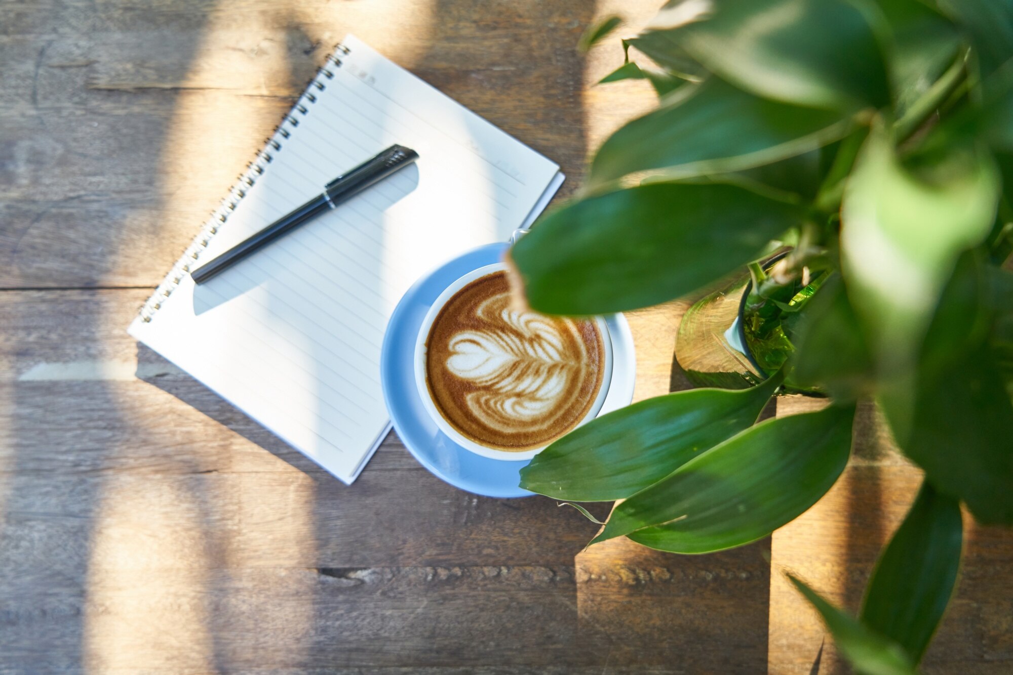 Mesa de cafetería con taza de café y libreta